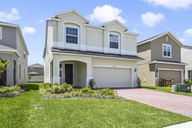 14655 Erice Ave, Clermont, FL 34714 - traditional-style home featuring decorative driveway, a garage, a front lawn, and a standing seam roof