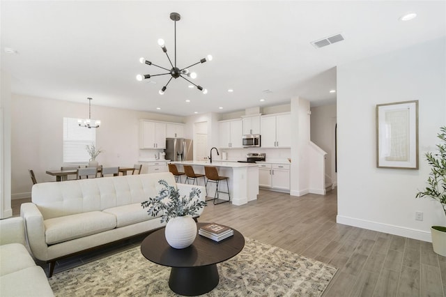 14655 Erice Ave, Clermont, FL 34714 - living area with a chandelier, light wood-style floors, baseboards, and recessed lighting