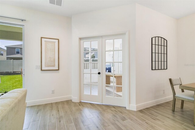 14655 Erice Ave, Clermont, FL 34714 - doorway to outside featuring french doors, light wood-style flooring, and baseboards