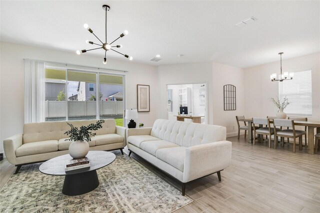 14655 Erice Ave, Clermont, FL 34714 - living room with a chandelier, light wood finished floors, and baseboards
