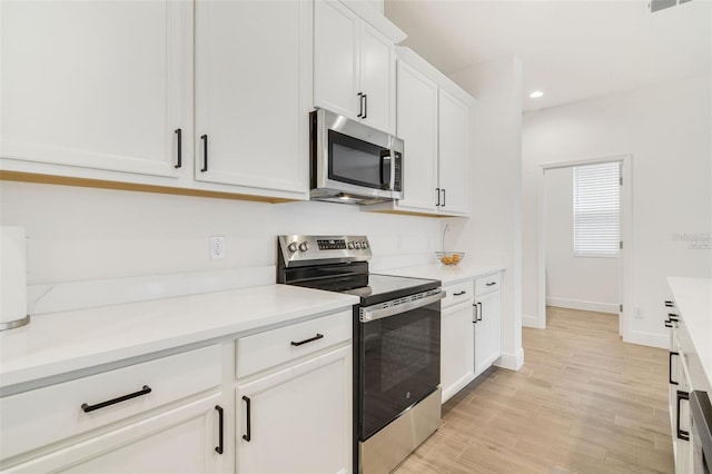 14655 Erice Ave, Clermont, FL 34714 - kitchen featuring stainless steel appliances, white cabinetry, light countertops, recessed lighting, and light wood finished floors