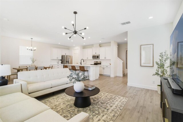 14655 Erice Ave, Clermont, FL 34714 - living room featuring a chandelier, light wood-style flooring, baseboards, and recessed lighting