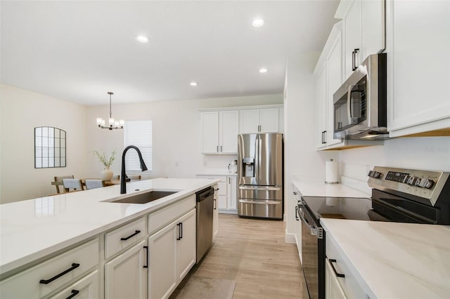 14655 Erice Ave, Clermont, FL 34714 - kitchen featuring appliances with stainless steel finishes, a sink, white cabinetry, light countertops, and light wood-style floors