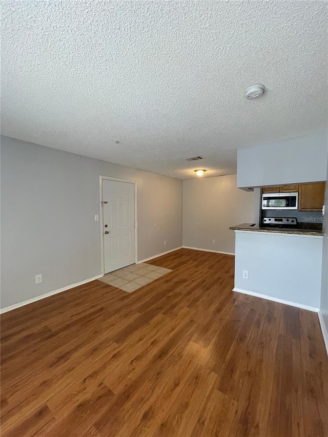 238 Afton Sq Unit 204, Altamonte Springs, FL 32714 - unfurnished living room with a textured ceiling, wood finished floors, and baseboards