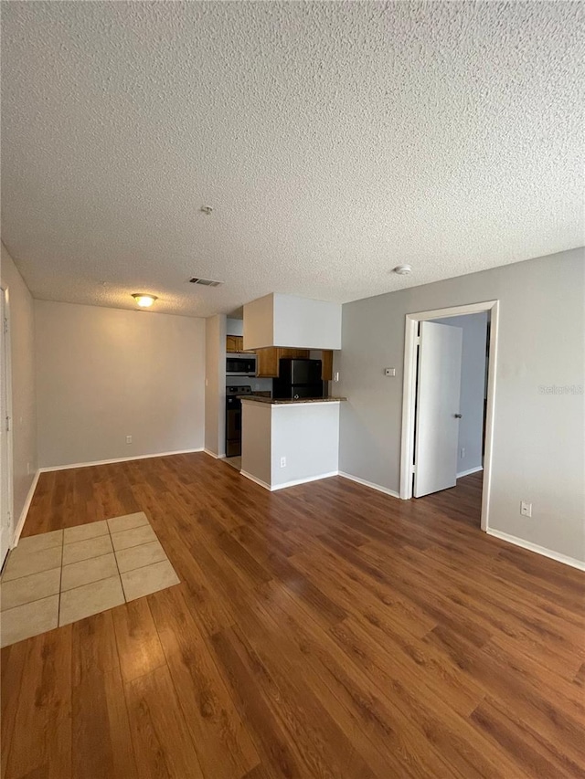 238 Afton Sq Unit 204, Altamonte Springs, FL 32714 - unfurnished living room featuring wood finished floors, a textured ceiling, and baseboards