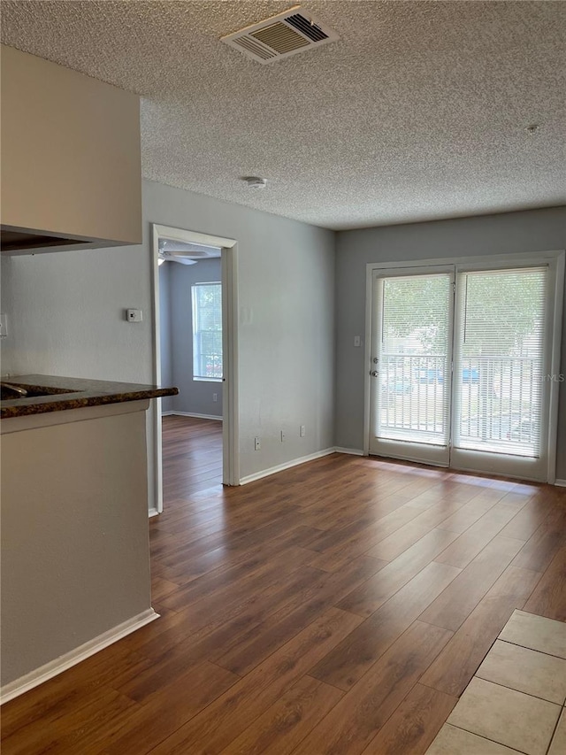 238 Afton Sq Unit 204, Altamonte Springs, FL 32714 - empty room featuring dark wood-type flooring, a textured ceiling, plenty of natural light, and baseboards