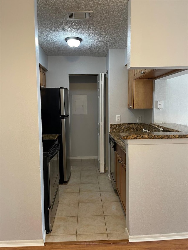 238 Afton Sq Unit 204, Altamonte Springs, FL 32714 - kitchen featuring stainless steel appliances, a textured ceiling, light tile patterned floors, and baseboards