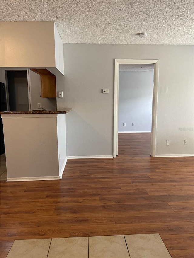 238 Afton Sq Unit 204, Altamonte Springs, FL 32714 - kitchen with a textured ceiling, wood finished floors, baseboards, and dark countertops