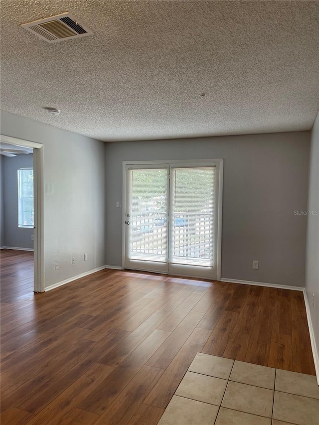 238 Afton Sq Unit 204, Altamonte Springs, FL 32714 - spare room with wood finished floors, plenty of natural light, a textured ceiling, and baseboards