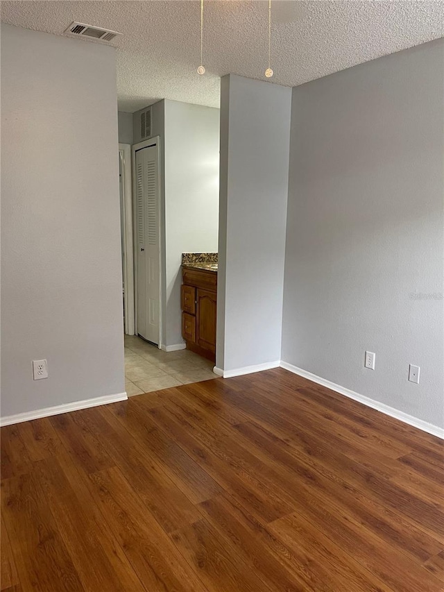 238 Afton Sq Unit 204, Altamonte Springs, FL 32714 - spare room with wood finished floors, baseboards, and a textured ceiling