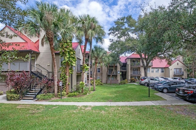 238 Afton Sq Unit 204, Altamonte Springs, FL 32714 - view of front facade featuring uncovered parking, stucco siding, metal roof, a front yard, and stairway