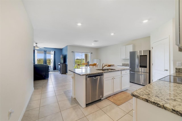 2135 E Old Mill Dr, Deltona, FL 32725 - kitchen featuring stainless steel appliances, a sink, a kitchen island with sink, open floor plan, and white cabinets