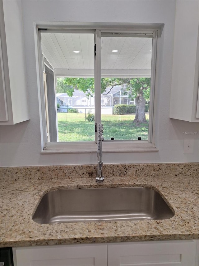 11282 SW 62nd Avenue Rd, Ocala, FL 34476 - kitchen view of a sink, white cabinetry, and light stone countertops