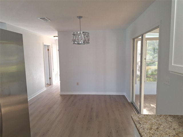11282 SW 62nd Avenue Rd, Ocala, FL 34476 - unfurnished dining area featuring light wood-type flooring, a chandelier, and baseboards