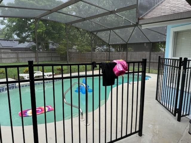 2514 Dovetail Dr, Ocoee, FL 34761 - view of swimming pool with a fenced backyard, glass enclosure, and a patio