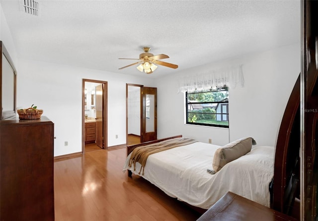 1830 W Clinton Dr, Saint Cloud, FL 34769 - bedroom featuring wood finished floors, a textured ceiling, a ceiling fan, baseboards, and ensuite bathroom