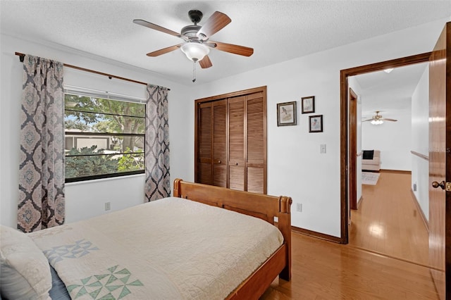 1830 W Clinton Dr, Saint Cloud, FL 34769 - bedroom featuring a closet, wood finished floors, a textured ceiling, ceiling fan, and baseboards