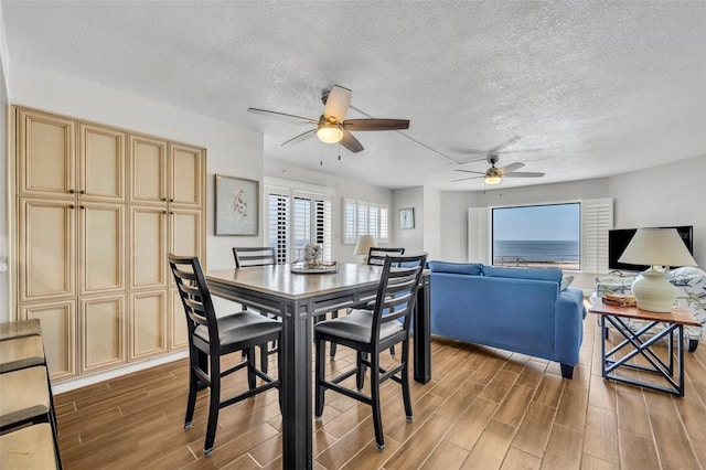 5207 S Atlantic Ave Unit 225, New Smyrna Beach, FL 32169 - dining space with a ceiling fan, light wood-style flooring, and a textured ceiling