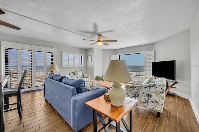 5207 S Atlantic Ave Unit 225, New Smyrna Beach, FL 32169 - living area with ceiling fan, wood finished floors, a textured ceiling, and baseboards