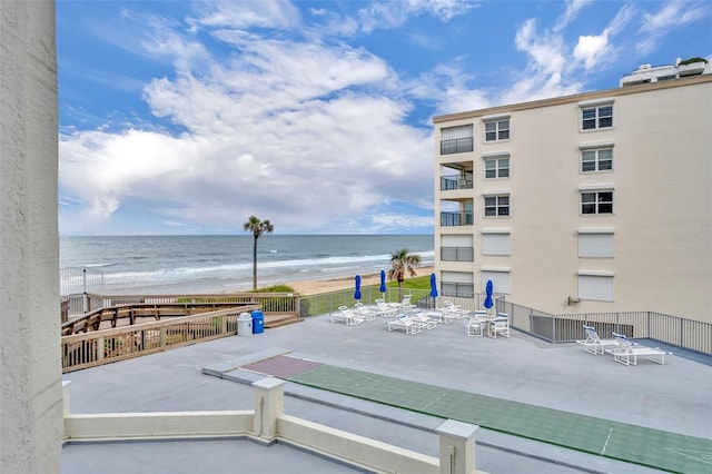 5207 S Atlantic Ave Unit 225, New Smyrna Beach, FL 32169 - view of patio featuring fence, view of water and beach, and shuffleboard