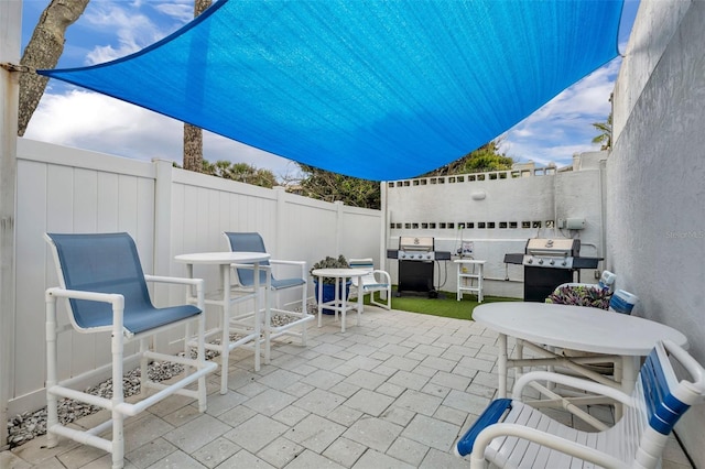 5207 S Atlantic Ave Unit 225, New Smyrna Beach, FL 32169 - view of patio with grilling area, a fenced backyard, and outdoor dining area