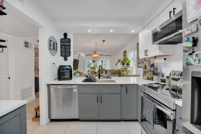 5635 Blue Shadows Ct Unit 3, Orlando, FL 32811 - kitchen with stainless steel appliances, gray cabinetry, light countertops, light tile patterned floors, and recessed lighting