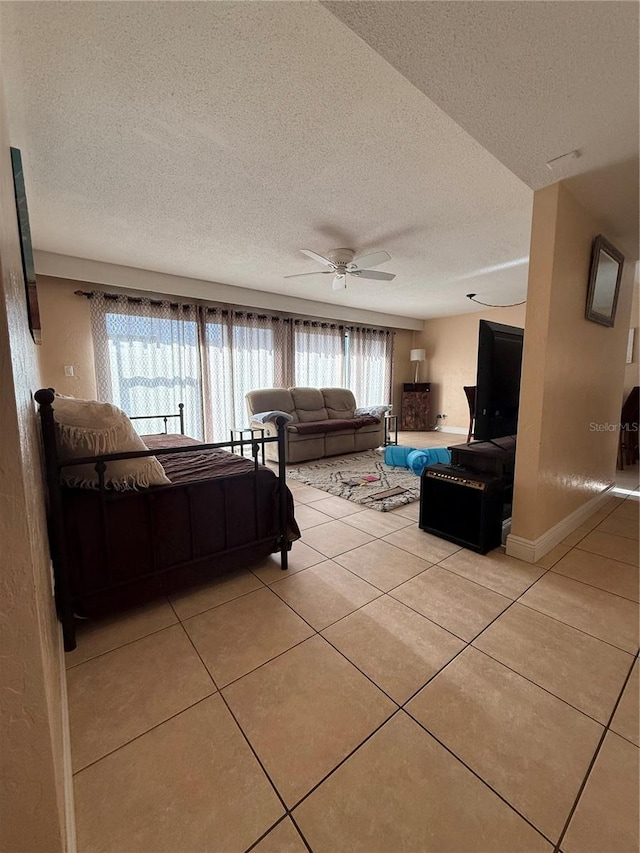 821 Pinewood Ct Unit 821, Haines City, FL 33844 - bedroom with light tile patterned floors, a textured ceiling, ceiling fan, and baseboards