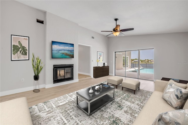 6 Cimmaron Dr, Palm Coast, FL 32137 - living area with wood finished floors, a glass covered fireplace, ceiling fan, and baseboards