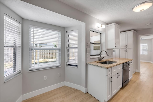 6 Cimmaron Dr, Palm Coast, FL 32137 - kitchen with a sink, black dishwasher, light wood finished floors, a textured ceiling, and white cabinets