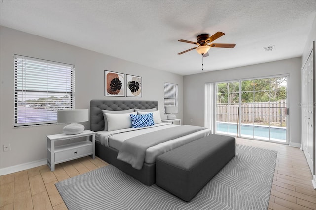 6 Cimmaron Dr, Palm Coast, FL 32137 - bedroom with access to outside, baseboards, light wood-style flooring, ceiling fan, and a textured ceiling