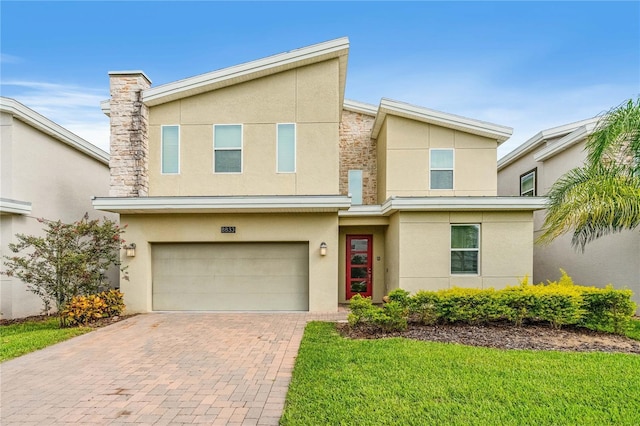 8833 Cruden Bay Ct, Davenport, FL 33896 - view of front of home featuring stucco siding, an attached garage, decorative driveway, a front lawn, and stone siding