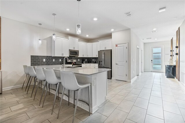 8833 Cruden Bay Ct, Davenport, FL 33896 - kitchen with stainless steel appliances, a peninsula, backsplash, light countertops, and a kitchen bar