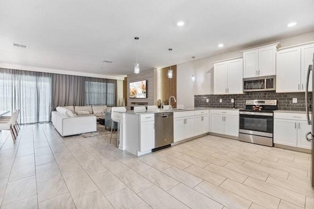 8833 Cruden Bay Ct, Davenport, FL 33896 - kitchen with stainless steel appliances, open floor plan, a peninsula, plenty of natural light, and recessed lighting