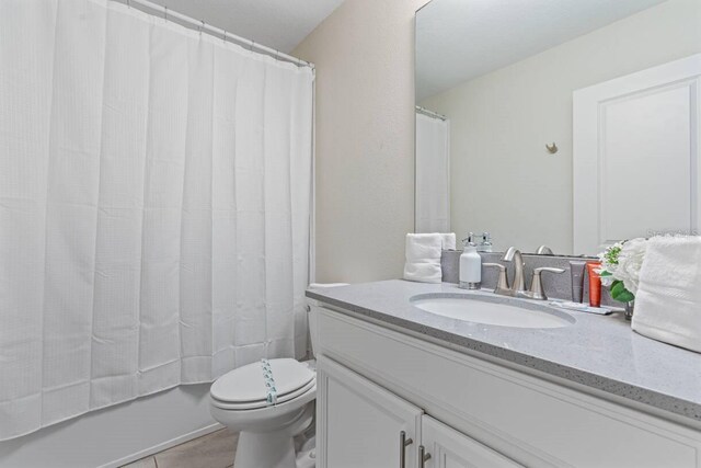 8833 Cruden Bay Ct, Davenport, FL 33896 - full bathroom with vanity, toilet, tile patterned flooring, and shower / bathtub combination with curtain