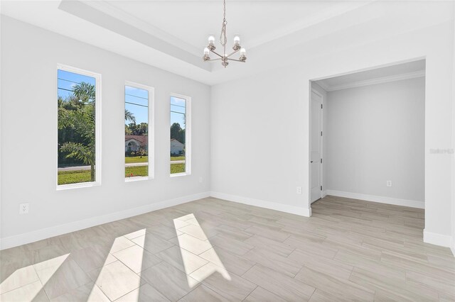 304 N Jungle Rd, Geneva, FL 32732 - unfurnished room featuring a chandelier, a raised ceiling, baseboards, and light wood finished floors