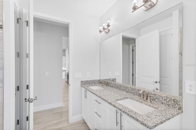 304 N Jungle Rd, Geneva, FL 32732 - bathroom featuring baseboards, double vanity, and wood finished floors