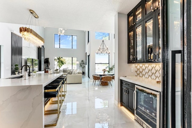 3924 SW 189th Ave, Miramar, FL 33029 - bar area with wine cooler, a chandelier, backsplash, light marble finish floors, and a sink