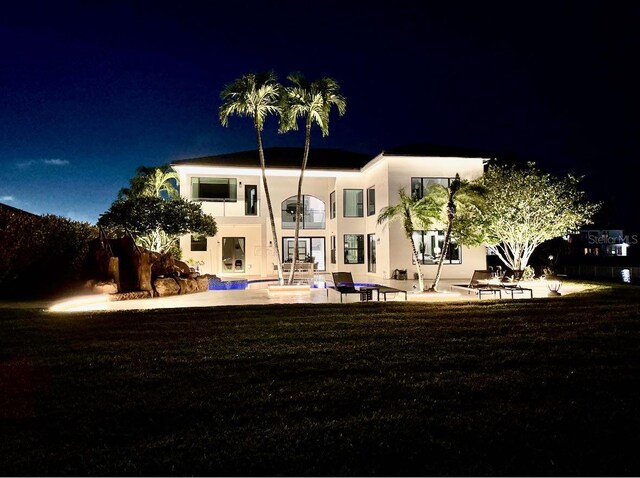 3924 SW 189th Ave, Miramar, FL 33029 - back of house at night featuring french doors, stucco siding, an outdoor pool, and a patio area