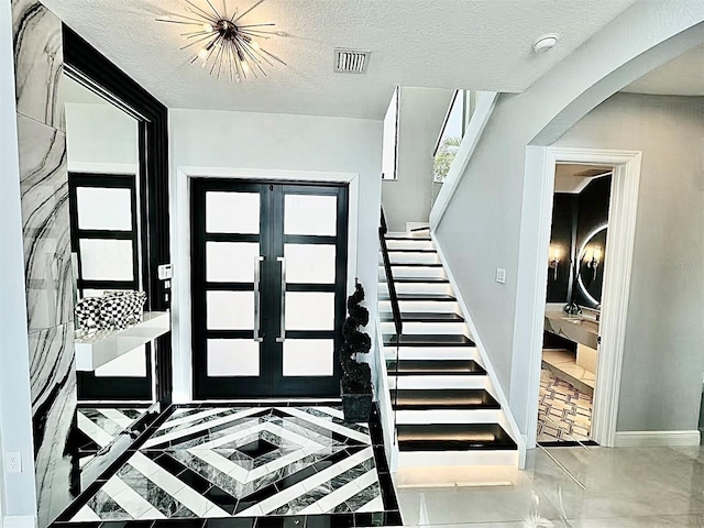 3924 SW 189th Ave, Miramar, FL 33029 - foyer with arched walkways, stairs, baseboards, french doors, and a textured ceiling