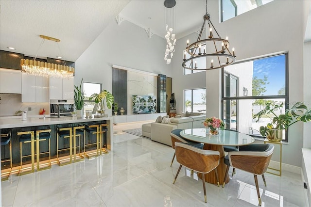 3924 SW 189th Ave, Miramar, FL 33029 - dining space with a chandelier, a towering ceiling, marble tiled floors, and plenty of natural light