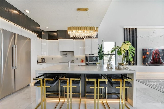 3924 SW 189th Ave, Miramar, FL 33029 - kitchen featuring stainless steel appliances, a chandelier, modern cabinets, white cabinetry, and light marble finish floors