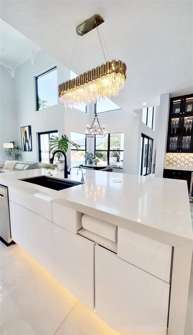 3924 SW 189th Ave, Miramar, FL 33029 - kitchen with a sink, open floor plan, a chandelier, white cabinetry, and light countertops