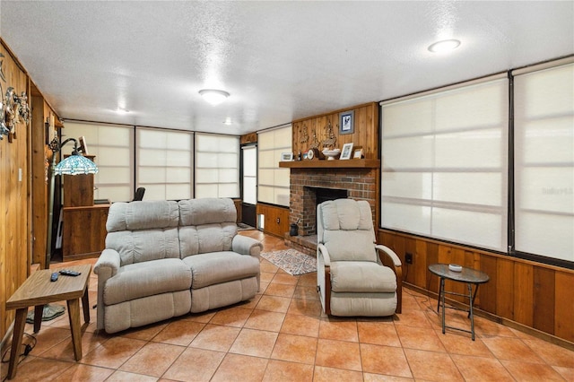 3118 Walnut St, Winter Haven, FL 33881 - living room featuring wooden walls, a brick fireplace, a textured ceiling, and light tile patterned floors