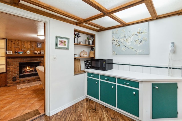 3118 Walnut St, Winter Haven, FL 33881 - kitchen with black microwave, coffered ceiling, green cabinets, a fireplace, and light countertops
