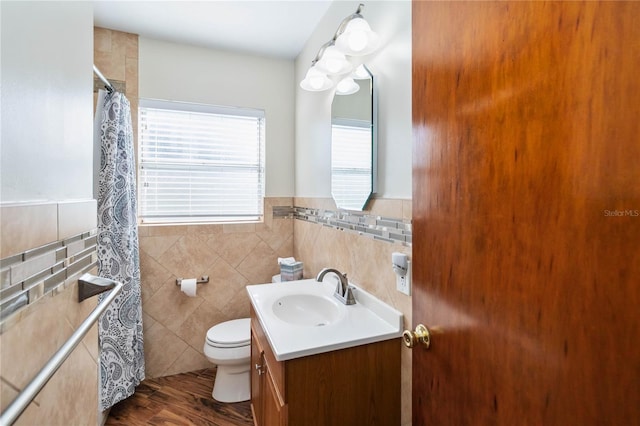 3118 Walnut St, Winter Haven, FL 33881 - full bathroom with vanity, tile walls, a shower with shower curtain, wainscoting, and wood finished floors