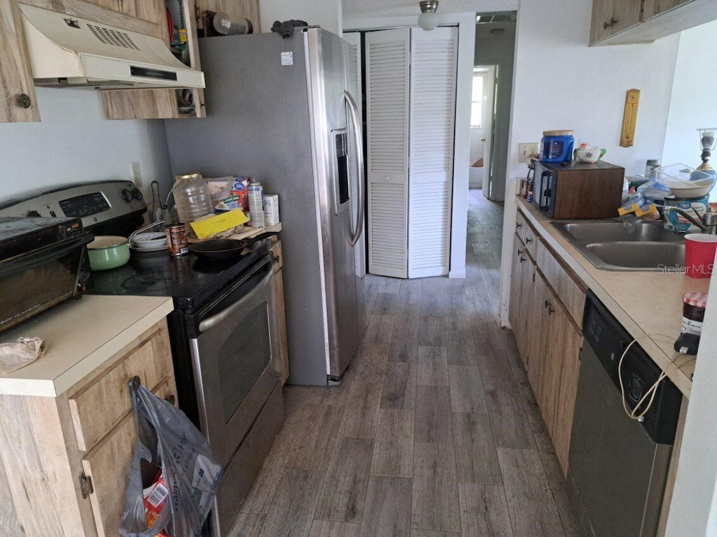 3607 Johnson Ct, Palm Harbor, FL 34684 - kitchen with stainless steel appliances, under cabinet range hood, a sink, wood finished floors, and light countertops