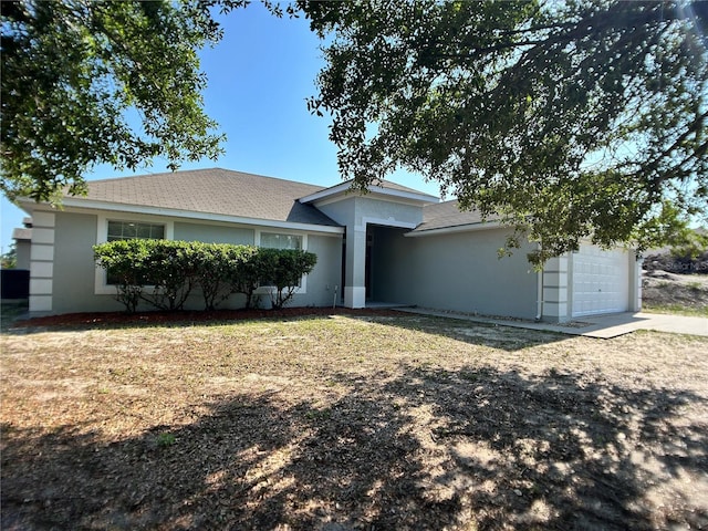 ranch-style house with a garage and stucco siding