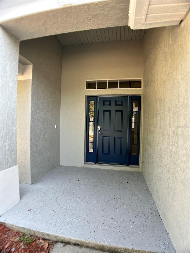 view of exterior entry with stucco siding