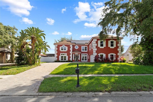 1254 Shelter Rock Rd, Orlando, FL 32835 - view of front facade featuring roof mounted solar panels, a front yard, decorative driveway, and stucco siding