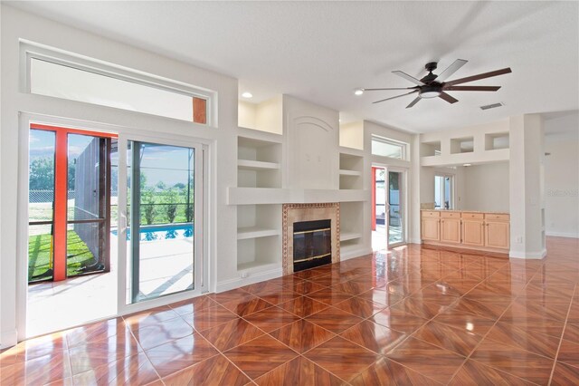 1254 Shelter Rock Rd, Orlando, FL 32835 - unfurnished living room featuring plenty of natural light, built in features, a tiled fireplace, recessed lighting, and ceiling fan